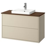 Beige bathroom cabinet with wooden top, rectangular white sink, chrome faucet.