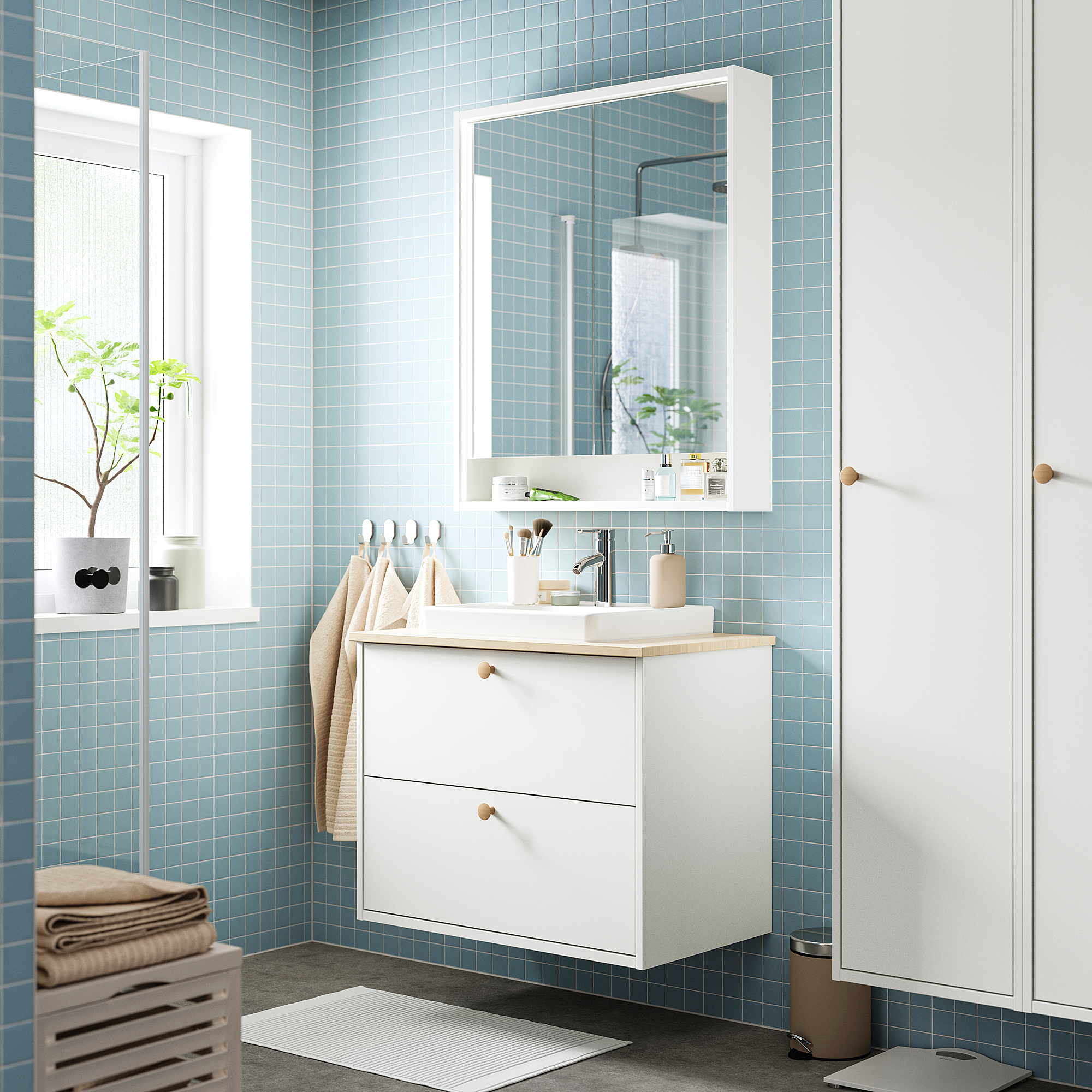 Modern white bathroom vanity, large mirror, blue tiles, beige towels.