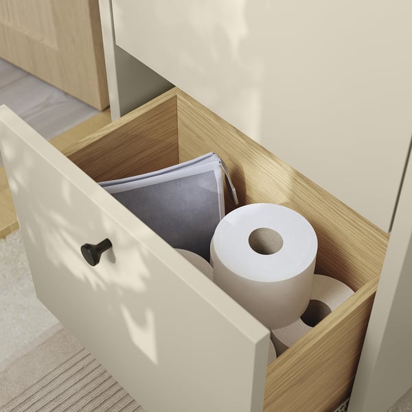 Open bathroom drawer showing toilet paper and mesh bag, demonstrating storage space in HAVBÄCK unit.