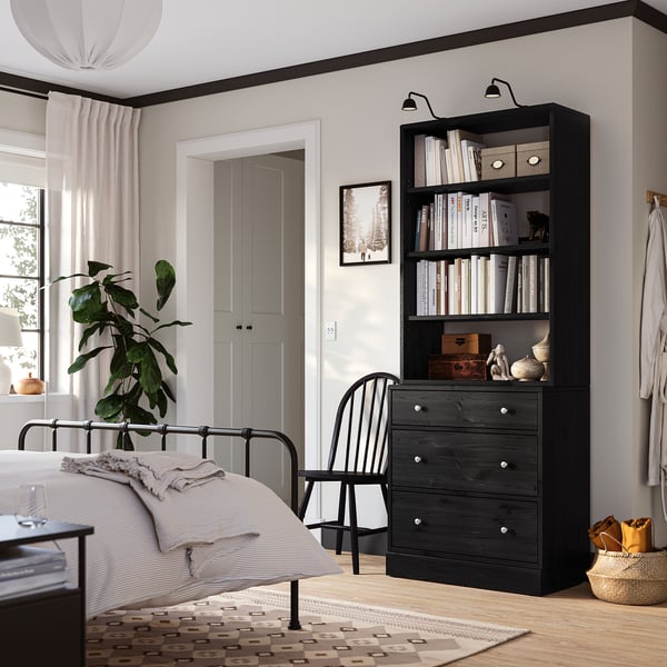 Bedroom with HAVSTA wooden chest and bookshelf, bed, window, and plant.