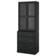 HAVSTA: tall black wooden cabinet with glass doors and three drawers, displaying rustic design.