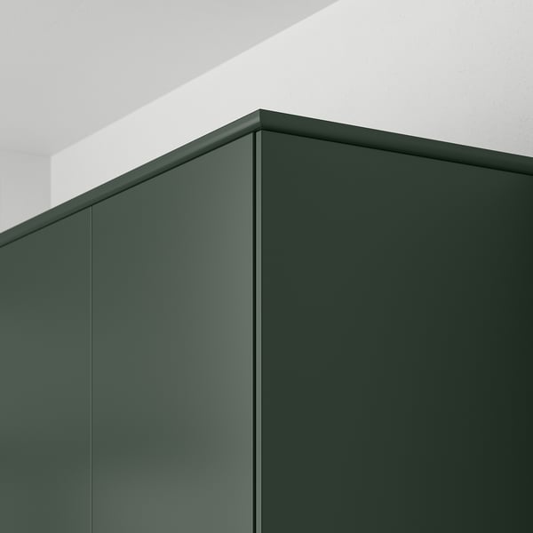 Dark green kitchen cabinet panels with straight lines and smooth surfaces, mounted on a white wall, demonstrating integrated cabinet design.