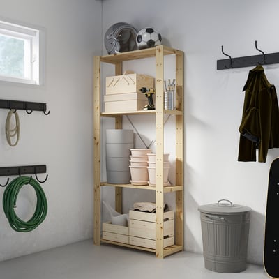 Wooden HEJNE storage unit in garage with shelves and bins for gear, tools, and plants.