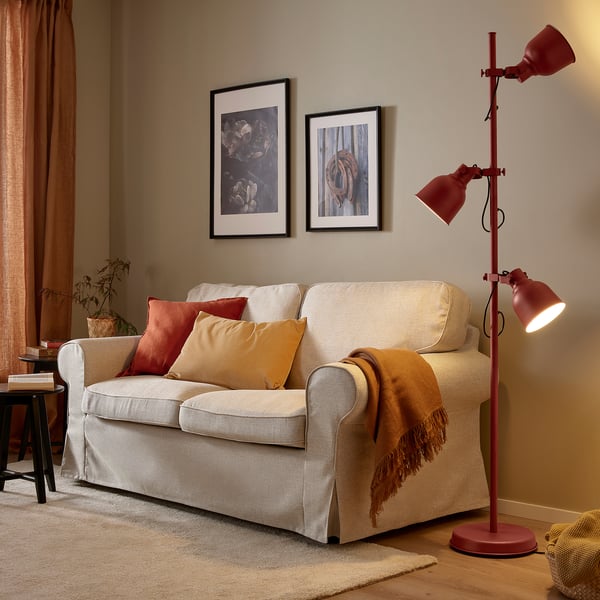 Living room with cream sofa, orange accents, and red industrial-style HEKTAR lamp.