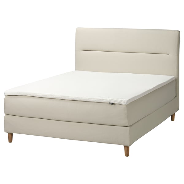 HEMFJÄLLET bed in beige, upholstered fabric, wooden legs, rectangular shape, soft headboard.