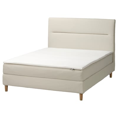 Minimalist ivory bed with padded headboard, wood legs, and white mattress.