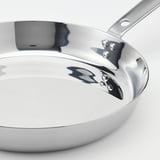 Shiny stainless steel frying pan with a long handle and three rivets. Sleek, polished interior for easy cooking and cleaning.
