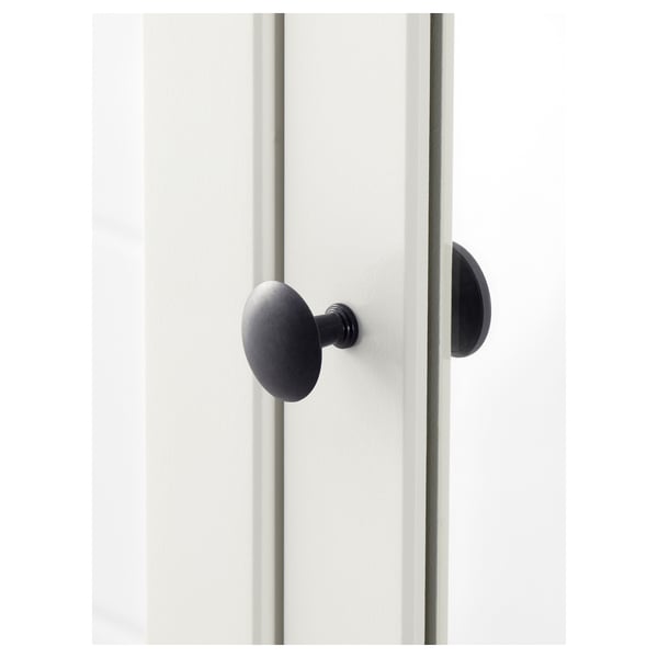 Modern, sleek door handle in matte black, mounted on a pristine white door. High quality, minimalist design.