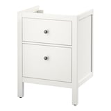 An ikea HEMNES white bathroom vanity cabinet with two drawers. It has a simple, classic design with black knobs.