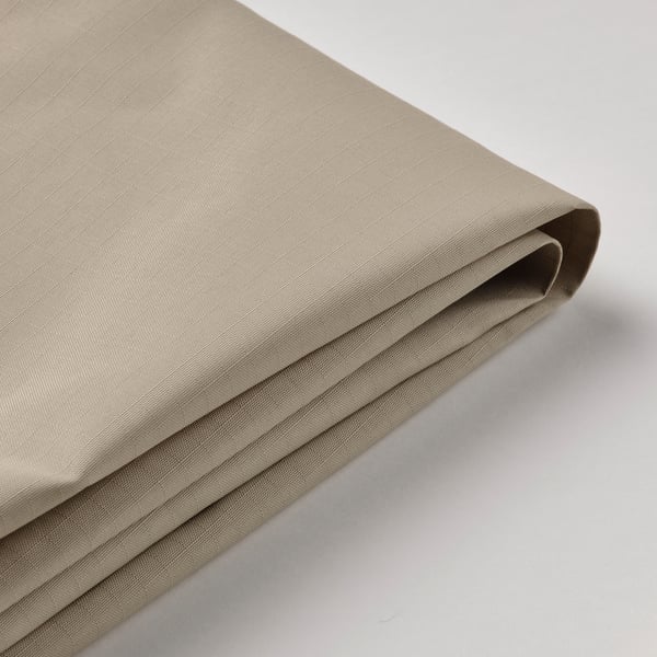 Folded fabric canopy close-up, smooth texture, light neutral color.