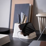 White HÖNSNÄT phone & pen holder, sleek & compact, holds smartphone & pens, beside office items.