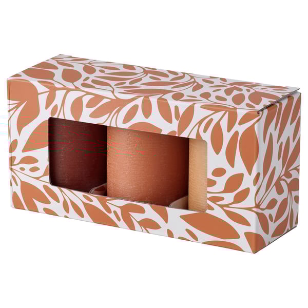 A HÖSTAGILLE box with three brown pillar candles, patterned with earthy tones.