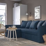 Modern blue HOLMSUND sofa as bed in room with white cabinet and window.