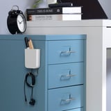 Blue cabinet with magnetic organizer holding pens, headphones, and alarm clock on top.