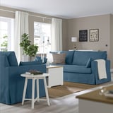 Blue living room with HYLTARP sofa, armchair, lamp, and large window.