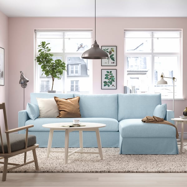 Light blue sectional sofa, coffee table, rug, windows, framed art