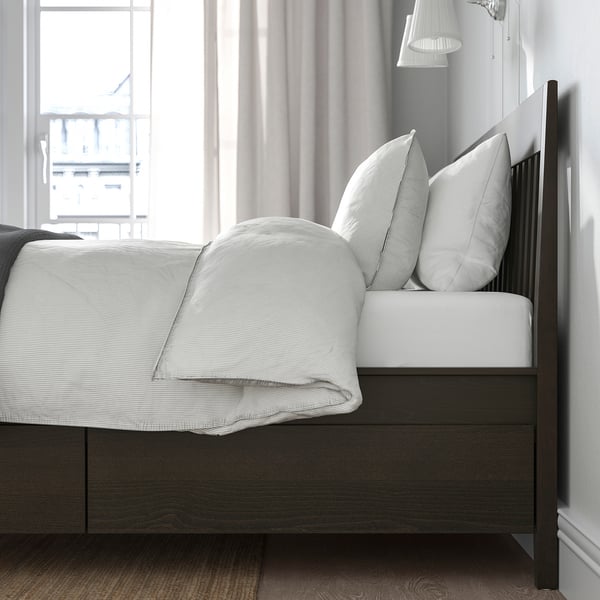 Bed with built-in storage drawers under mattress, soft-closing feature, wooden frame and slatted base.