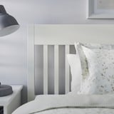 Modern IDANÄS bed with storage and lamp on bedside table, styled with pillows.