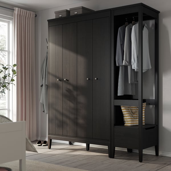 Dark wood wardrobe with bifold doors, open side for hanging clothes, and a striped bag on the shelf.