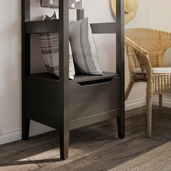 Modern dark wood storage unit with open shelves and drawers, featuring striped cushions.