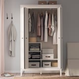 A white IDANÄS wardrobe with open bifold doors displaying clothes and organized storage boxes inside.