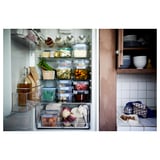 Neatly organized fridge and kitchen counter with various food items and containers.