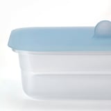 Close-up of clear plastic food container with light blue lid, sealed tight for freshness.