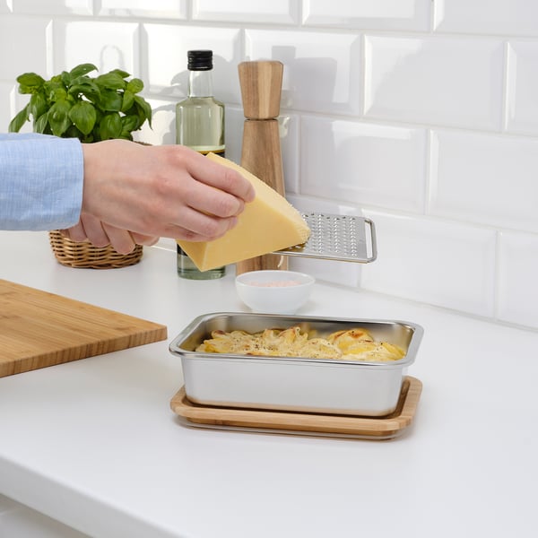 Grating cheese over container on kitchen counter.