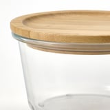 Close-up of a clear glass jar with a bamboo lid, showcasing the natural wood texture and durable seal.