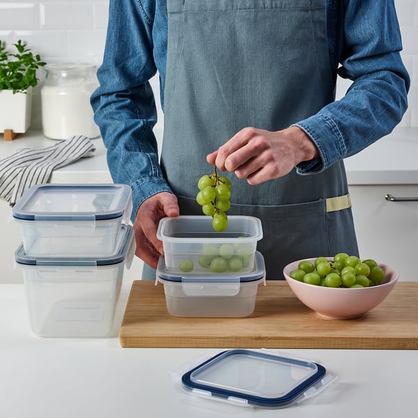 Person storing grapes in IKEA 365+ food container on kitchen counter.