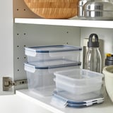 Clear plastic food containers, various sizes, stacked neatly on shelf, ideal for storing leftovers, transparent lids for easy viewing.