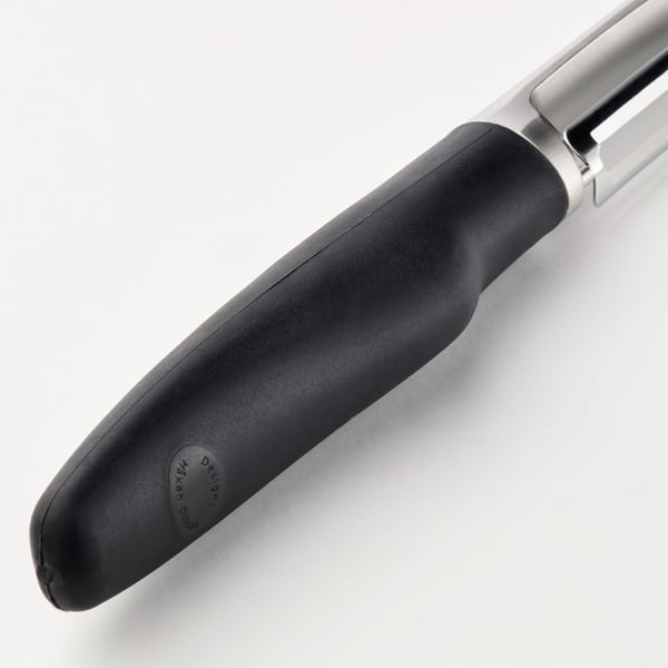 Black kitchen peeler with silver accents and ergonomic grip.