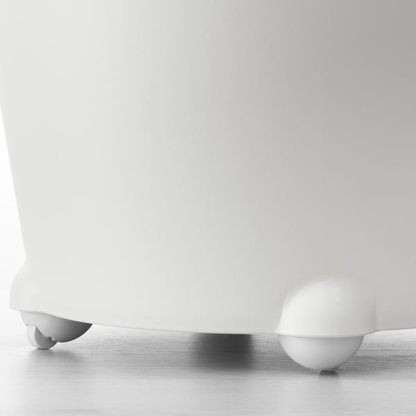 White ikea self-watering planter on floor, close-up of sturdy spherical feet.