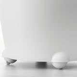 White ikea self-watering planter on floor, close-up of sturdy spherical feet.