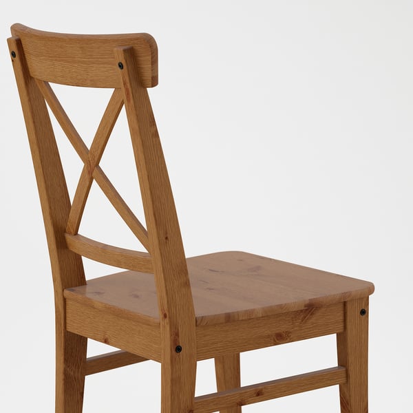 Sturdy wooden chair with carved back support, simple yet elegant design, crafted from solid pine.