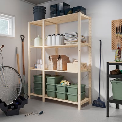 Light wood IVAR shelves store green bins, spray cans, and tools. Tidy and practical for garages.