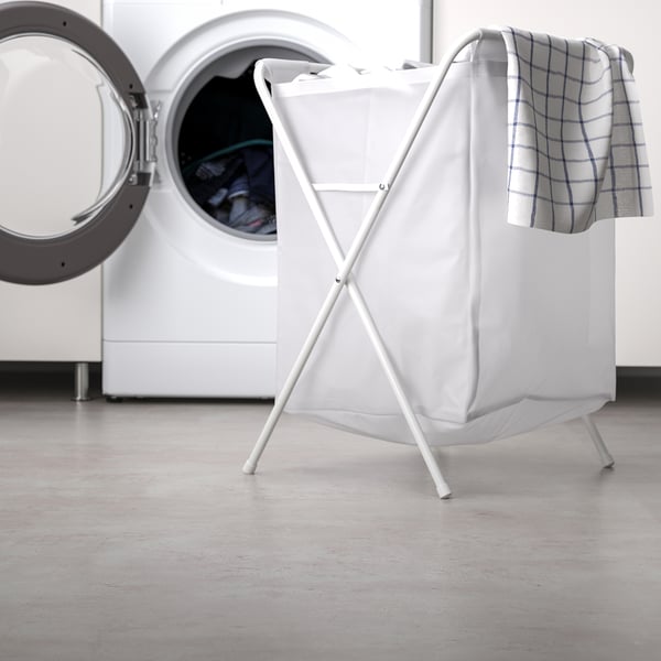 White laundry basket next to washing machine. Lightweight, foldable, holds 8 kg laundry.