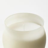 Top-down view of a single, unlit scented candle with a wick, in a clear glass container, simply designed.