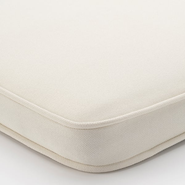 Close-up of a plush, beige chair cushion with a smooth, durable fabric and double-stitched edges, capturing its soft texture and comfort.