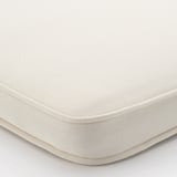 Close-up of a plush, beige chair cushion with a smooth, durable fabric and double-stitched edges, capturing its soft texture and comfort.