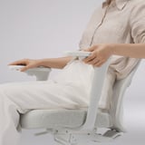 Person adjusting lumbar support of ergonomic office chair.