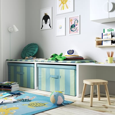 Kids room with green striped JÄTTEBJÖRN toy box, bright art, and blue turtle rug.