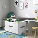 White storage bin, ideal for kids room, holding toys and accessories, positioned under a bed.