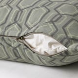 A cushion cover with a green geometric pattern and a hidden zipper for easy removal.