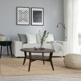 Modern living room with JAKOBSFORS coffee table, flowers, and wall art.
