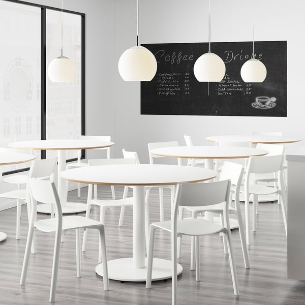 Modern cafe with round tables and white chairs. Menu board displays coffee drinks. Chairs stackable, ready assembled.
