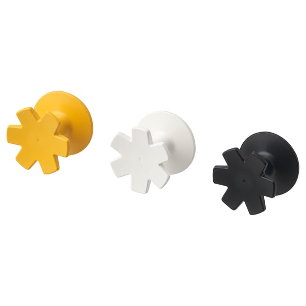 Three colorful snowflake-shaped hooks, yellow, white, and black; adhesive backs, made from abs plastic, for wall decoration and storage.