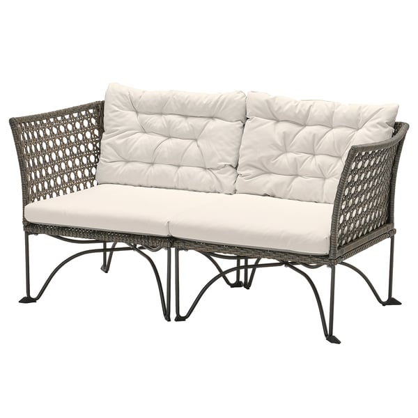 Modern wicker outdoor sofa in gray with white cushions.