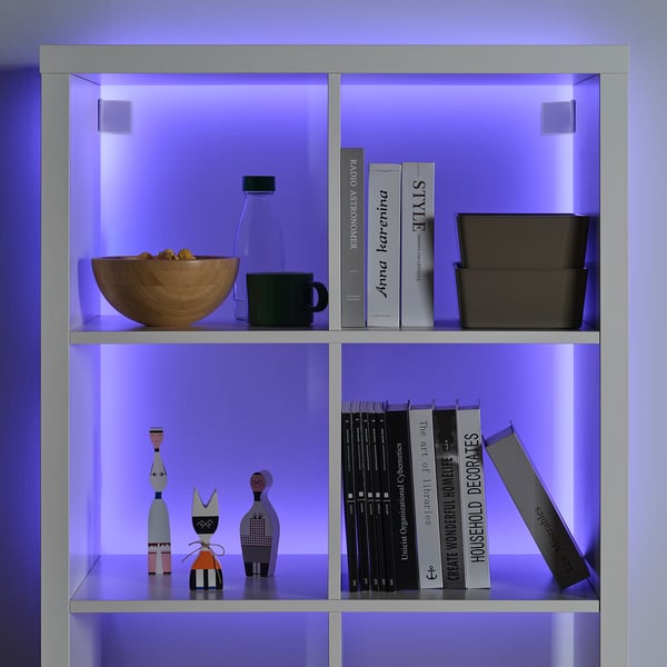 Blue led-lit shelf with bowl, vase, mug, books, and decor.