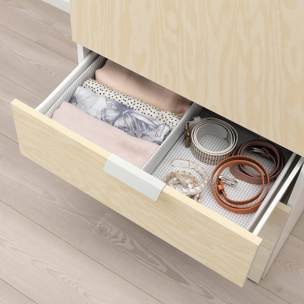 Open wooden drawer showing neatly organized underwear in compartments with belts on right side.